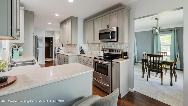 415 W Lawrence Ave, Charlotte, MI 48813 - kitchen featuring stainless steel appliances, independent washer and dryer, a sink, gray cabinets, and backsplash