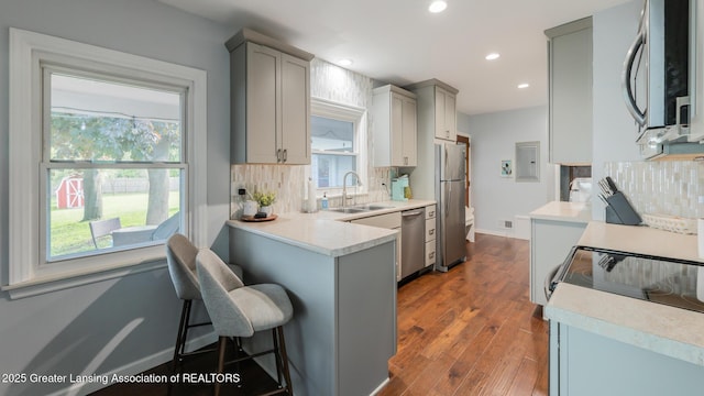 415 W Lawrence Ave, Charlotte, MI 48813 - kitchen with appliances with stainless steel finishes, a sink, gray cabinetry, decorative backsplash, and recessed lighting