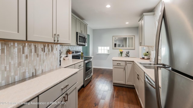 415 W Lawrence Ave, Charlotte, MI 48813 - kitchen featuring stainless steel appliances, baseboards, tasteful backsplash, dark wood-style floors, and light countertops