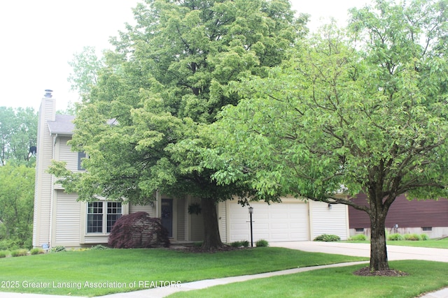 5740 Bearcreek Dr, Lansing, MI 48917 - obstructed view of property featuring concrete driveway, a chimney, a garage, and a front lawn