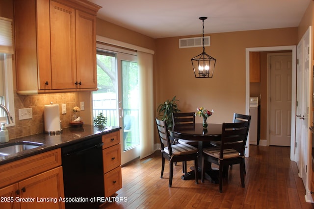 5740 Bearcreek Dr, Lansing, MI 48917 - dining room featuring a chandelier, wood-type flooring, and washer / dryer