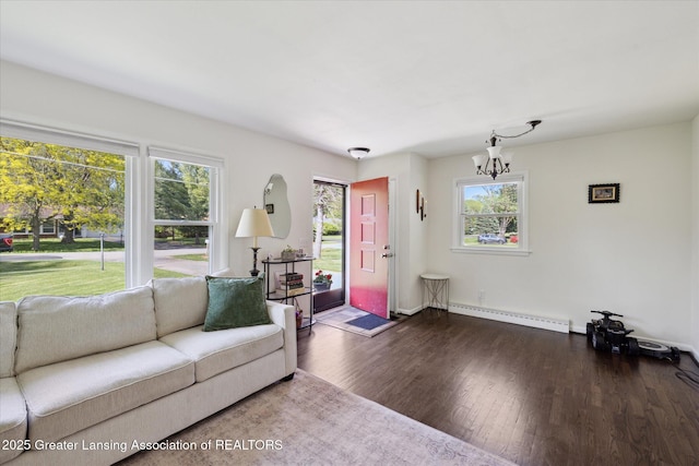 1571 Forest Hills Dr, Okemos, MI 48864 - living room featuring baseboard heating, healthy amount of natural light, wood finished floors, and a chandelier