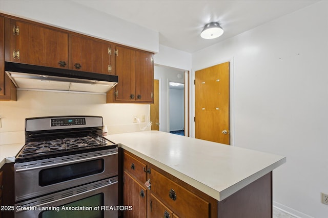 1116 W Service Rd, Mason, MI 48854 - kitchen with range with two ovens, under cabinet range hood, a peninsula, and light countertops