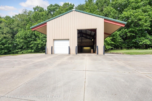 1116 W Service Rd, Mason, MI 48854 - garage featuring a detached garage and view of wooded area