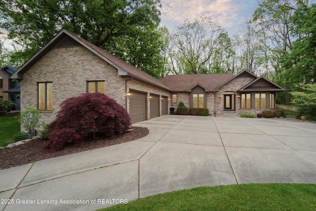 12728 Oneida Woods Trl, Grand Ledge, MI 48837 - view of front of home with driveway, an attached garage, a chimney, and brick siding