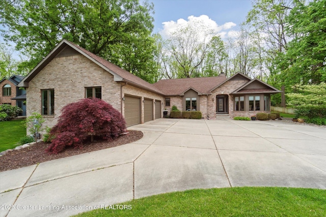 12728 Oneida Woods Trl, Grand Ledge, MI 48837 - view of front of home featuring a garage, driveway, a chimney, and brick siding
