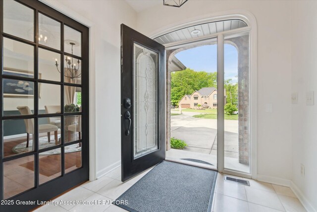 12728 Oneida Woods Trl, Grand Ledge, MI 48837 - entrance foyer featuring a chandelier, tile patterned floors, and baseboards