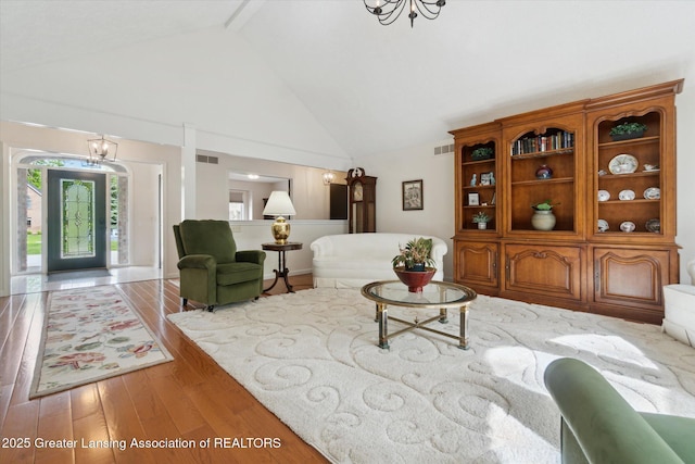 12728 Oneida Woods Trl, Grand Ledge, MI 48837 - living area with high vaulted ceiling, a chandelier, and wood finished floors