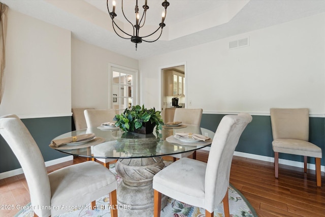12728 Oneida Woods Trl, Grand Ledge, MI 48837 - dining space featuring a chandelier, wood finished floors, baseboards, and a tray ceiling