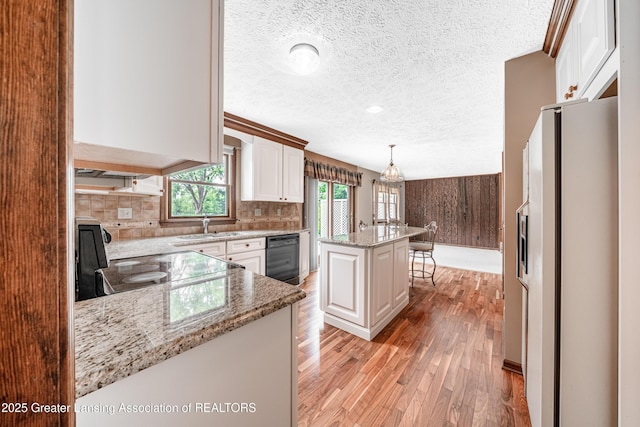 1932 Maple Shade Dr, Williamston, MI 48895 - kitchen featuring white fridge with ice dispenser, a textured ceiling, range with electric stovetop, light wood finished floors, and black dishwasher