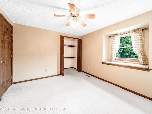 1932 Maple Shade Dr, Williamston, MI 48895 - unfurnished bedroom with light colored carpet, a textured ceiling, baseboards, and a ceiling fan