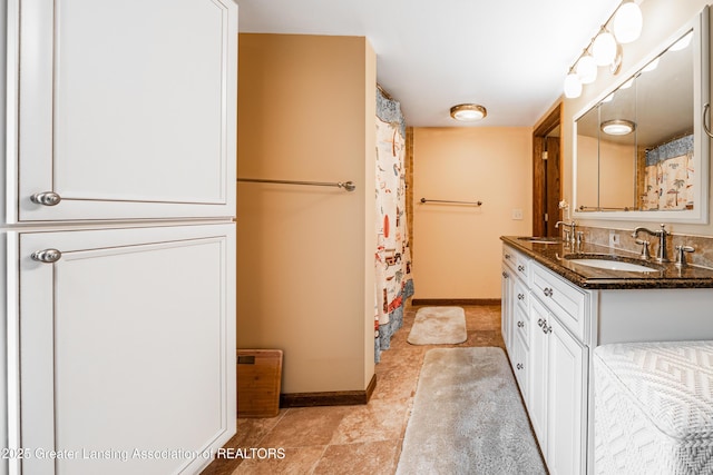 1932 Maple Shade Dr, Williamston, MI 48895 - bathroom featuring double vanity and baseboards