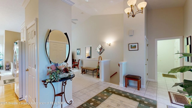 5167 Sapphire Cir, East Lansing, MI 48823 - corridor featuring high vaulted ceiling, an upstairs landing, light tile patterned floors, a chandelier, and baseboards
