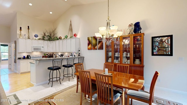 5167 Sapphire Cir, East Lansing, MI 48823 - dining area with high vaulted ceiling, a chandelier, and light wood-style flooring