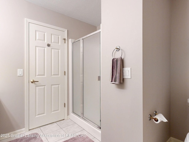 5167 Sapphire Cir, East Lansing, MI 48823 - full bathroom featuring a stall shower, tile patterned flooring, toilet, and baseboards