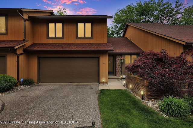 1615 Willow Creek Dr, Lansing, MI 48917 - view of front of home featuring an attached garage, roof with shingles, and asphalt driveway