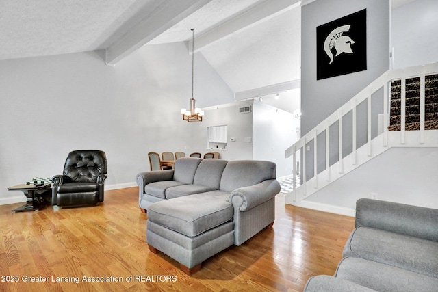 1615 Willow Creek Dr, Lansing, MI 48917 - living room with a chandelier, beam ceiling, wood finished floors, stairway, and high vaulted ceiling
