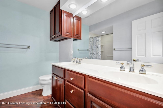 1615 Willow Creek Dr, Lansing, MI 48917 - bathroom with toilet, baseboards, double vanity, a shower with curtain, and wood finished floors