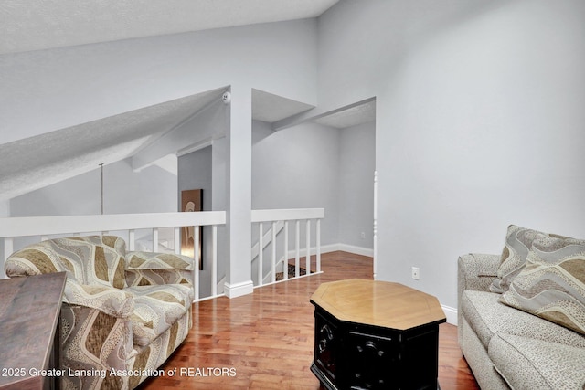 1615 Willow Creek Dr, Lansing, MI 48917 - living area featuring vaulted ceiling, wood finished floors, a textured ceiling, and baseboards