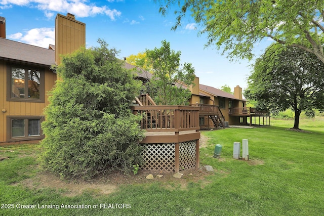 1615 Willow Creek Dr, Lansing, MI 48917 - view of grassy yard with a deck and stairs