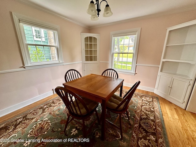 841 Huntington Rd, East Lansing, MI 48823 - dining room with a chandelier, light wood finished floors, crown molding, and baseboards