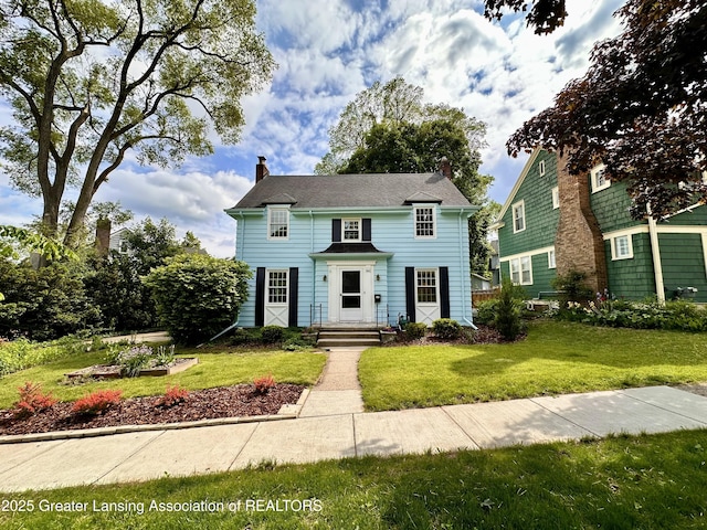841 Huntington Rd, East Lansing, MI 48823 - view of front of house with a front lawn and a chimney