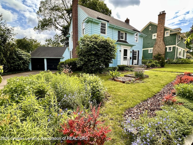 841 Huntington Rd, East Lansing, MI 48823 - view of front of house featuring a chimney, a front lawn, and a detached garage