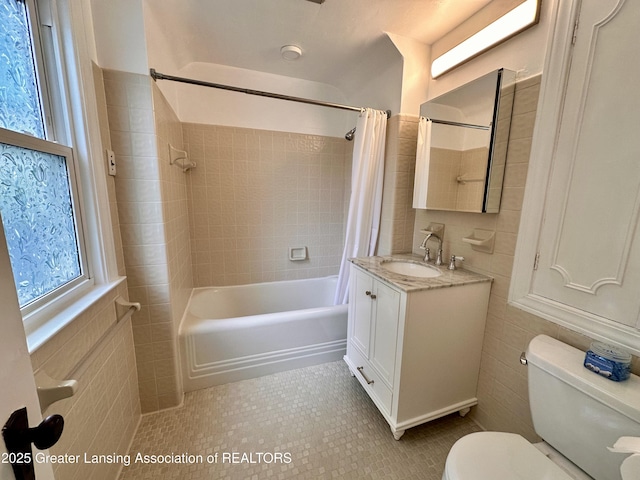 841 Huntington Rd, East Lansing, MI 48823 - bathroom featuring toilet, vanity, shower / tub combo, tile patterned flooring, and tile walls