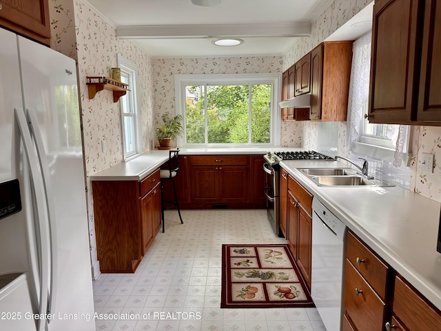 841 Huntington Rd, East Lansing, MI 48823 - kitchen featuring white appliances, wallpapered walls, under cabinet range hood, a sink, and light flooring