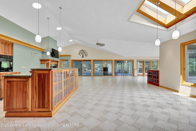 345 Linn Rd, Williamston, MI 48895 - kitchen with open floor plan, a skylight, oven, brown cabinetry, and ceiling fan