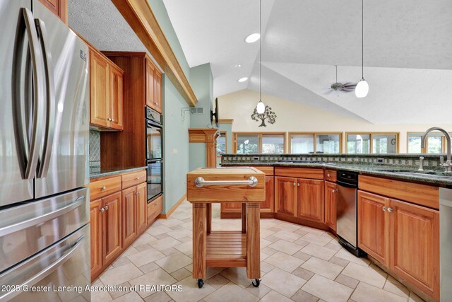 345 Linn Rd, Williamston, MI 48895 - kitchen with stainless steel appliances, vaulted ceiling, tasteful backsplash, decorative light fixtures, and dark stone countertops