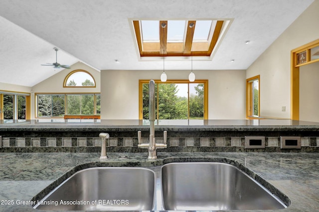 345 Linn Rd, Williamston, MI 48895 - kitchen view of a skylight, dark stone countertops, and ceiling fan