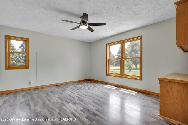 345 Linn Rd, Williamston, MI 48895 - unfurnished room featuring light wood-style flooring, ceiling fan, and a textured ceiling