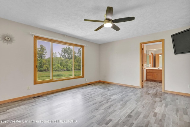 345 Linn Rd, Williamston, MI 48895 - spare room featuring light wood-style floors, a textured ceiling, and a ceiling fan