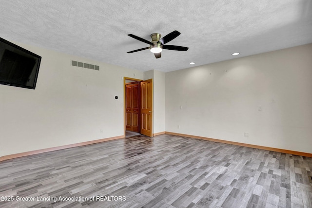 345 Linn Rd, Williamston, MI 48895 - unfurnished room with light wood finished floors, a ceiling fan, a textured ceiling, and recessed lighting