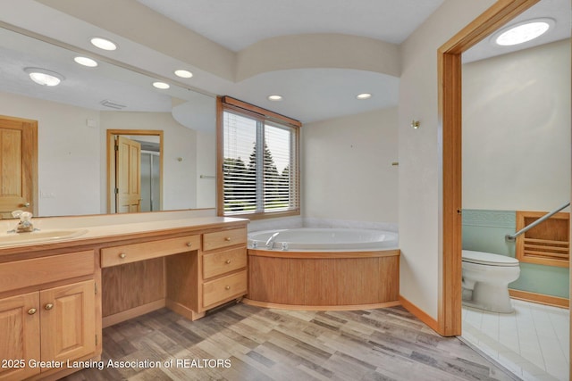 345 Linn Rd, Williamston, MI 48895 - bathroom with vanity, wood finished floors, a bath, and recessed lighting