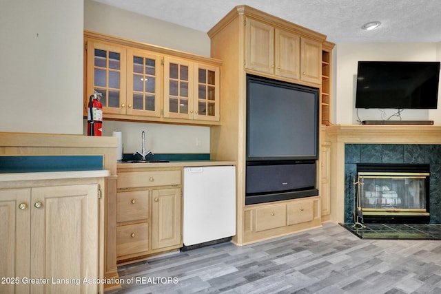 345 Linn Rd, Williamston, MI 48895 - kitchen featuring glass insert cabinets, white dishwasher, wood finished floors, light brown cabinetry, and a textured ceiling