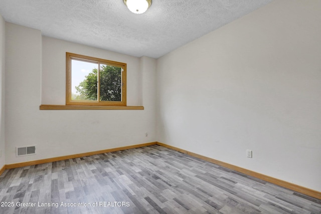 345 Linn Rd, Williamston, MI 48895 - empty room featuring wood finished floors and a textured ceiling
