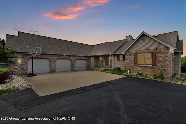 345 Linn Rd, Williamston, MI 48895 - view of front of property featuring brick siding, concrete driveway, a garage, a chimney, and a shingled roof
