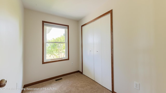 9271 W Burt Rd, Saint Charles, MI 48655 - unfurnished bedroom featuring light carpet, a closet, and baseboards