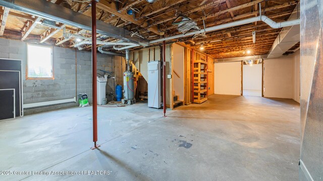 9271 W Burt Rd, Saint Charles, MI 48655 - below grade area featuring stairs, gas water heater, and a water softener