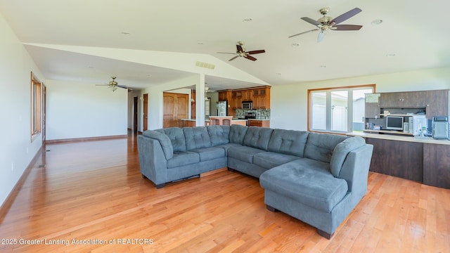 9271 W Burt Rd, Saint Charles, MI 48655 - living area with vaulted ceiling, light wood-style flooring, a ceiling fan, and baseboards