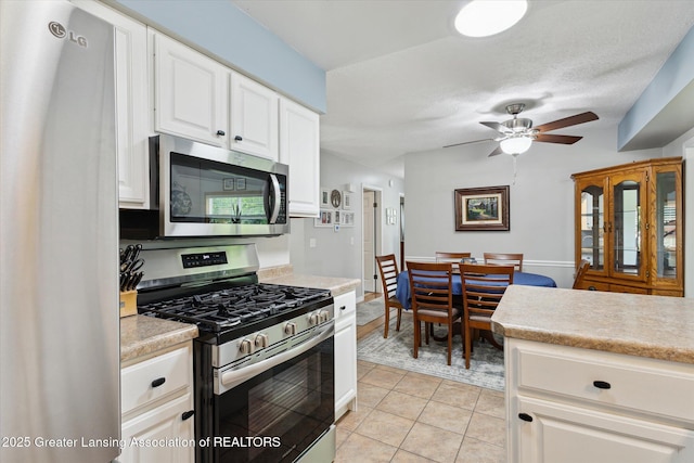 10470 Barnes Hwy, Eaton Rapids, MI 48827 - kitchen featuring appliances with stainless steel finishes, light countertops, white cabinetry, and a ceiling fan