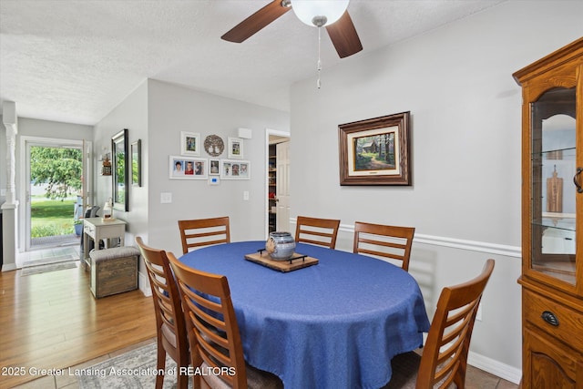 10470 Barnes Hwy, Eaton Rapids, MI 48827 - dining room with a ceiling fan, a textured ceiling, wood finished floors, and baseboards