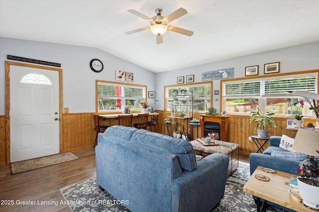 10470 Barnes Hwy, Eaton Rapids, MI 48827 - living room featuring wood finished floors, wainscoting, a ceiling fan, vaulted ceiling, and wooden walls