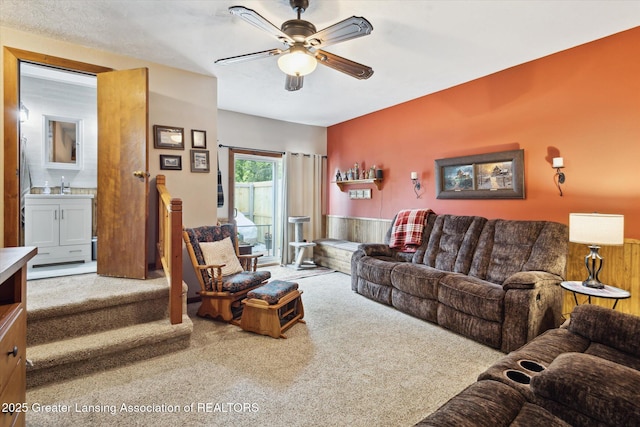 10470 Barnes Hwy, Eaton Rapids, MI 48827 - living area featuring carpet flooring, a ceiling fan, and wainscoting