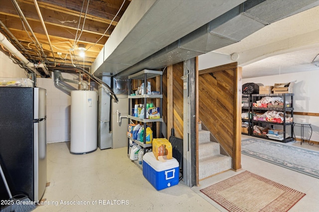 10470 Barnes Hwy, Eaton Rapids, MI 48827 - unfinished basement featuring freestanding refrigerator, water heater, and stairs