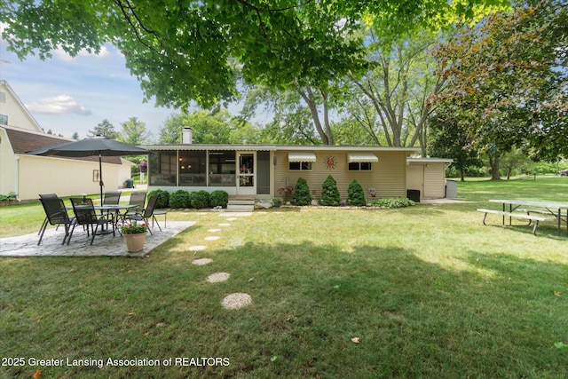 4951 Shore Ln, Perrinton, MI 48871 - rear view of property featuring a sunroom, a lawn, a patio area, and a chimney