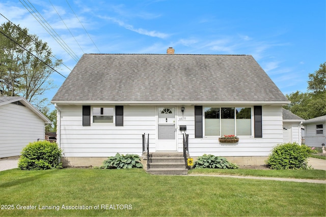 4810 Cherryland Dr, Lansing, MI 48910 - view of front of property with a chimney, a front yard, and a shingled roof