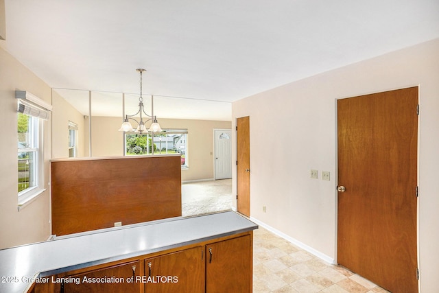 4810 Cherryland Dr, Lansing, MI 48910 - unfurnished dining area with a chandelier, baseboards, and light floors